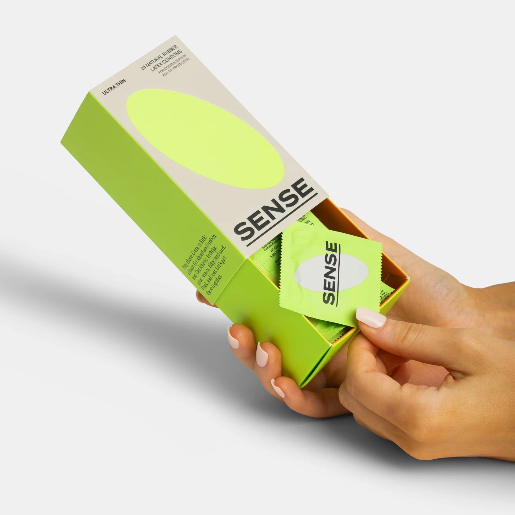 Hands of a woman opening a pack of sense ultra thin natural rubber latex condoms 24 pack