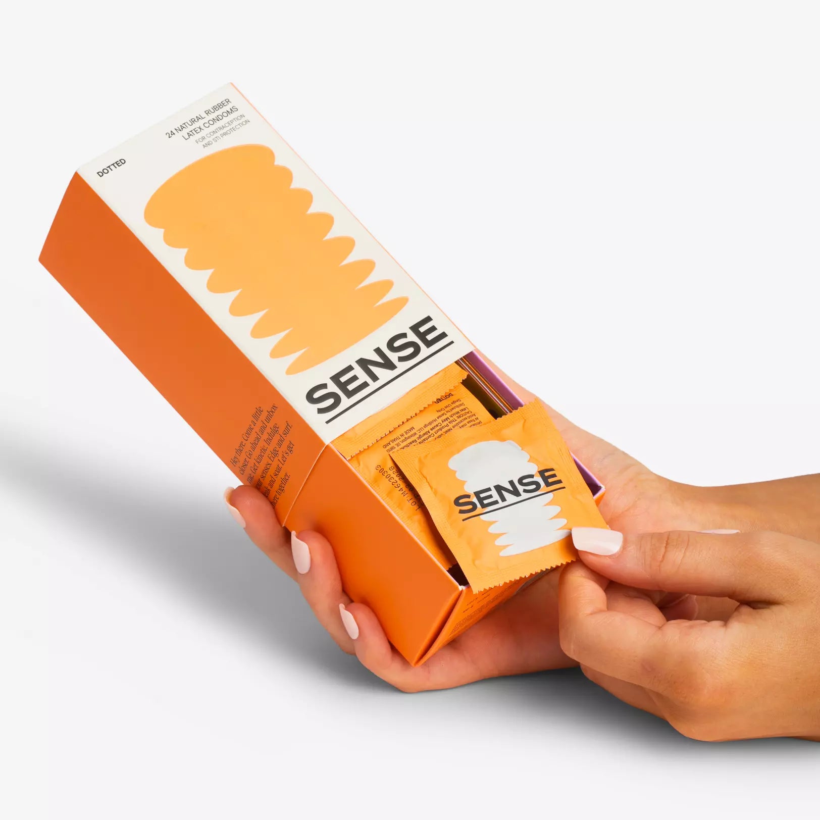 Woman opening a pack of sense premium natural rubber latex condoms 24 pack